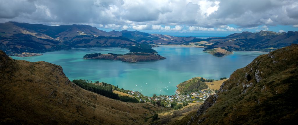 View of Diamond Harbour over turquoise sea surrounded by mountains